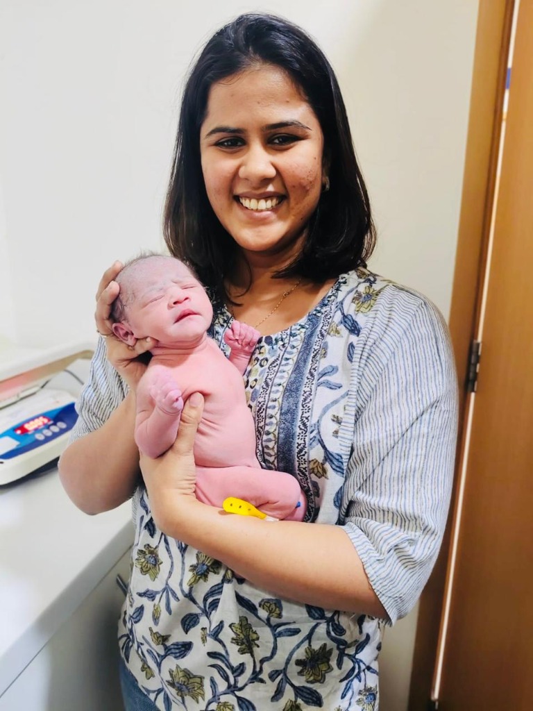 Dr. Aastha Jain holding swaddled newborn baby